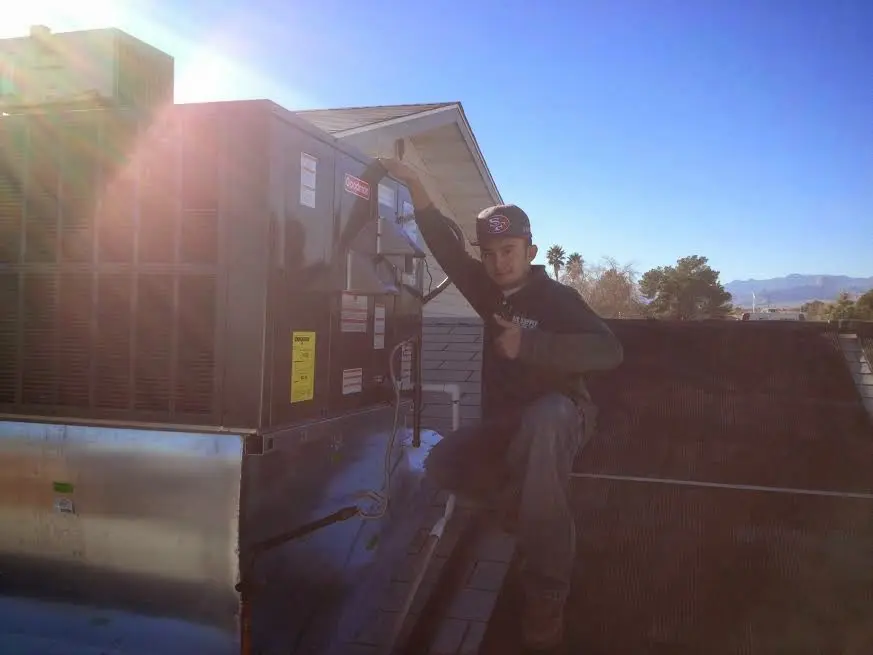HVAC technician performing AC Tune-Up on a rooftop unit in Turlock