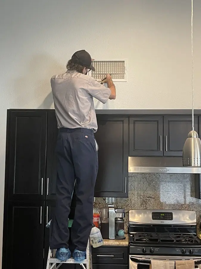 Technician inspecting an air vent during HVAC service in Turlock
